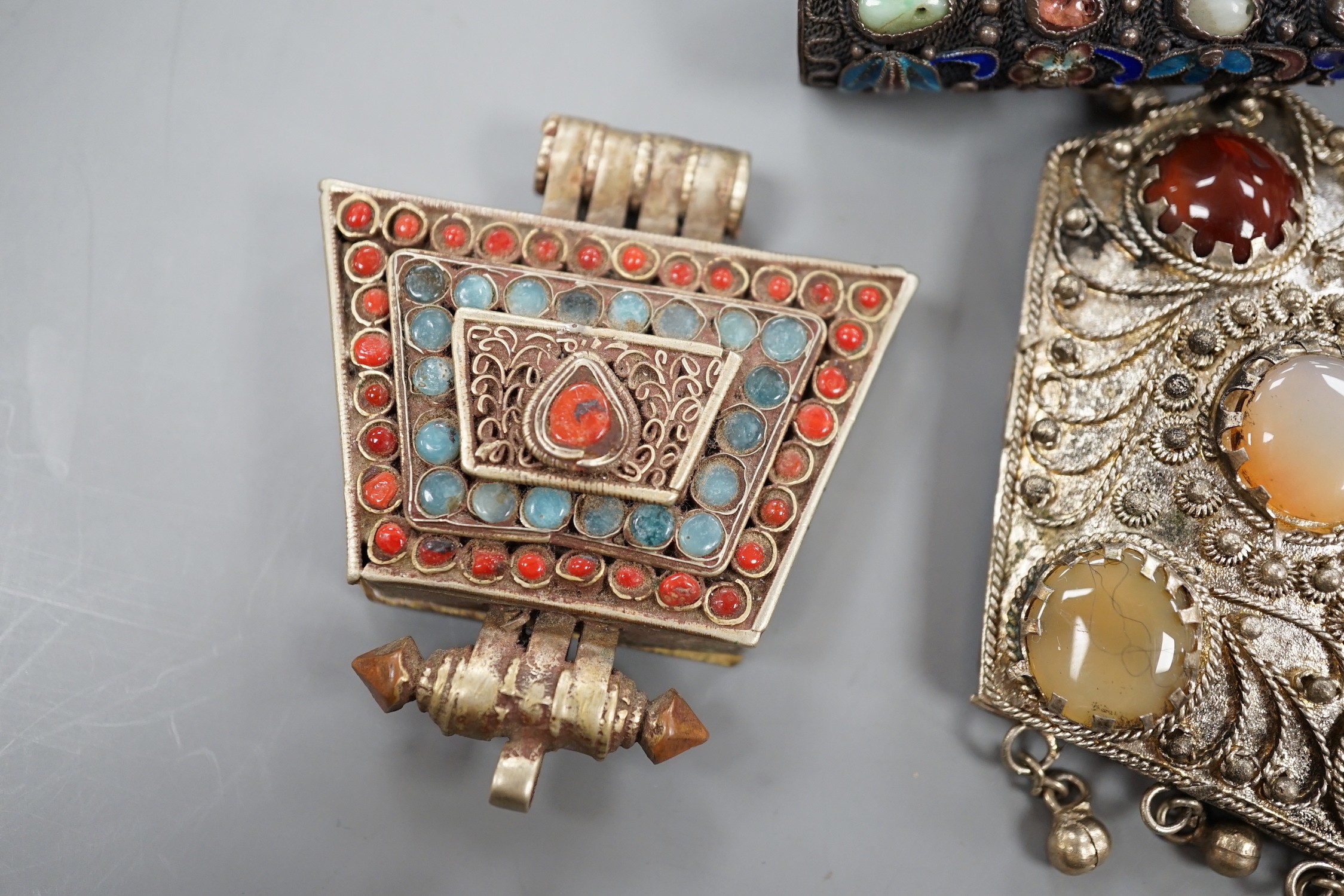 A Chinese filigree white metal, hardstone and enamel set nail guard, 86mm, together with two other Middle Eastern items.